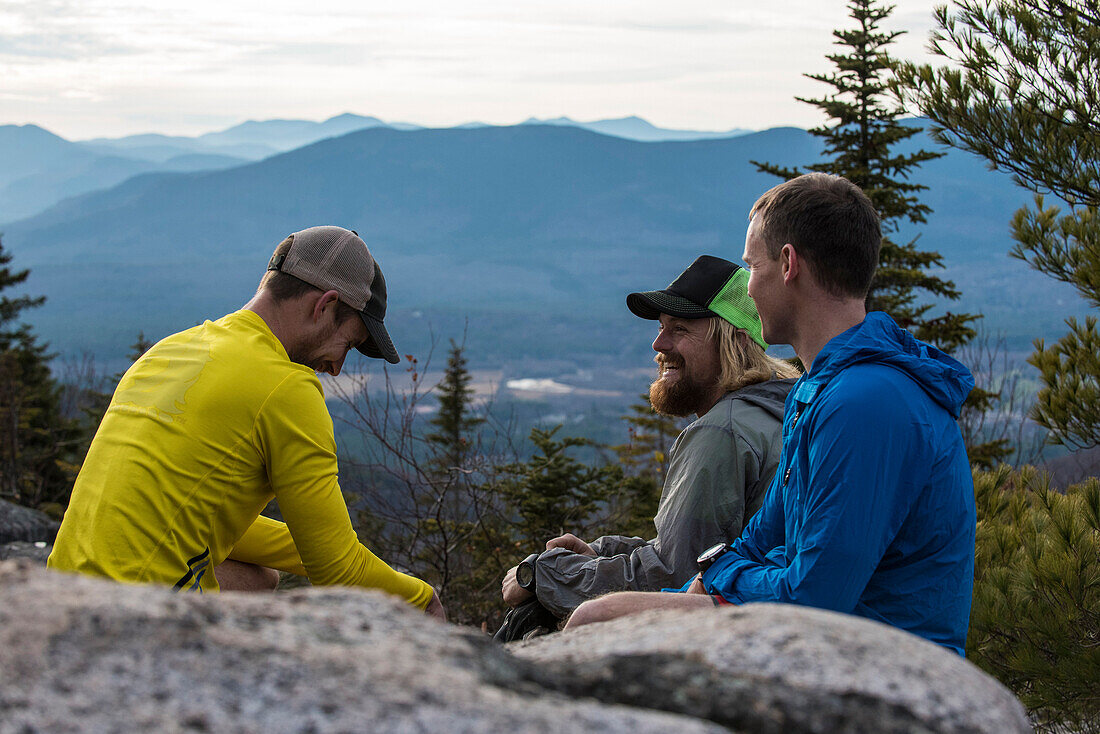 Trail runners taking a break high above North Conway, NH on the summit of Black Cap Mt.
