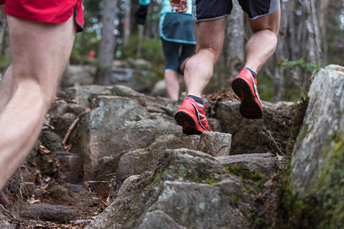 Trail runners on hard granite rocks adn ledges in the White Mountains of NH.