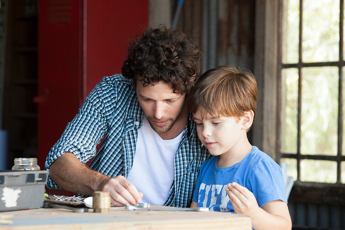 Child helping his father in workshop