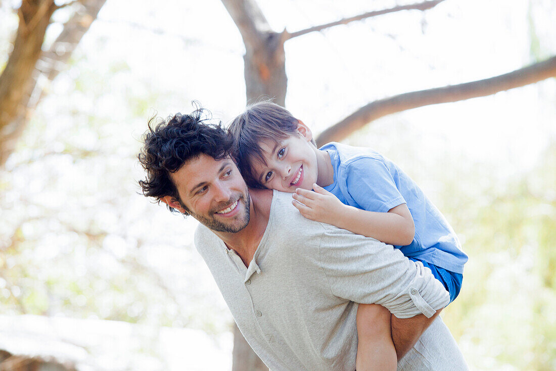 Father giving little boy piggyback ride