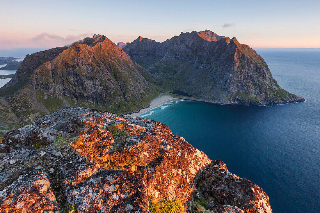 Blick vom Gipfel des Ryten auf den Sandstrand der Kvalvika Bucht und die umliegenden Berge im letzten Abendlicht, Moskenesøy, Lofoten, Norwegen, Skandinavien