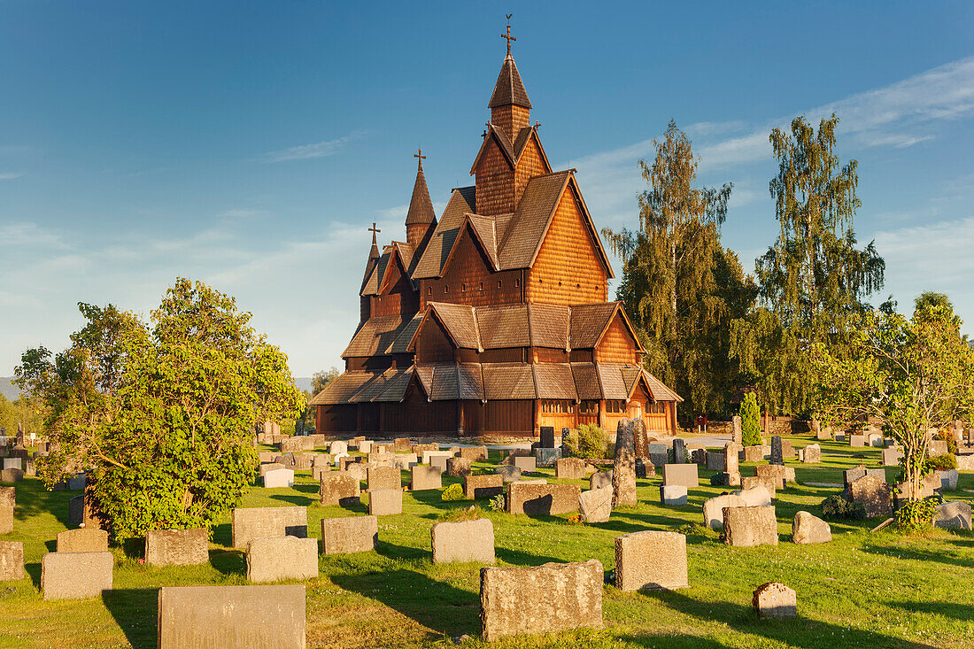 Stabkirche Heddal mit Grabsteinen in der Abendsonne im Sommer, Notodden, Telemark, Norwegen, Skandinavien