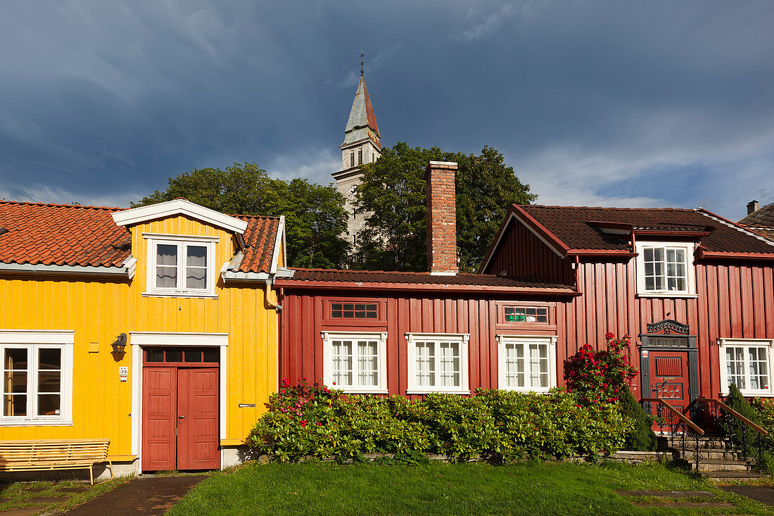 Blick auf bunte Häuser im Künstlerviertel Bakklandet mit der Kirche Bakke Bydelshus im Hintergrund, Nygata, Trondheim, Sør-Trøndelag, Norwegen, Skandinavien