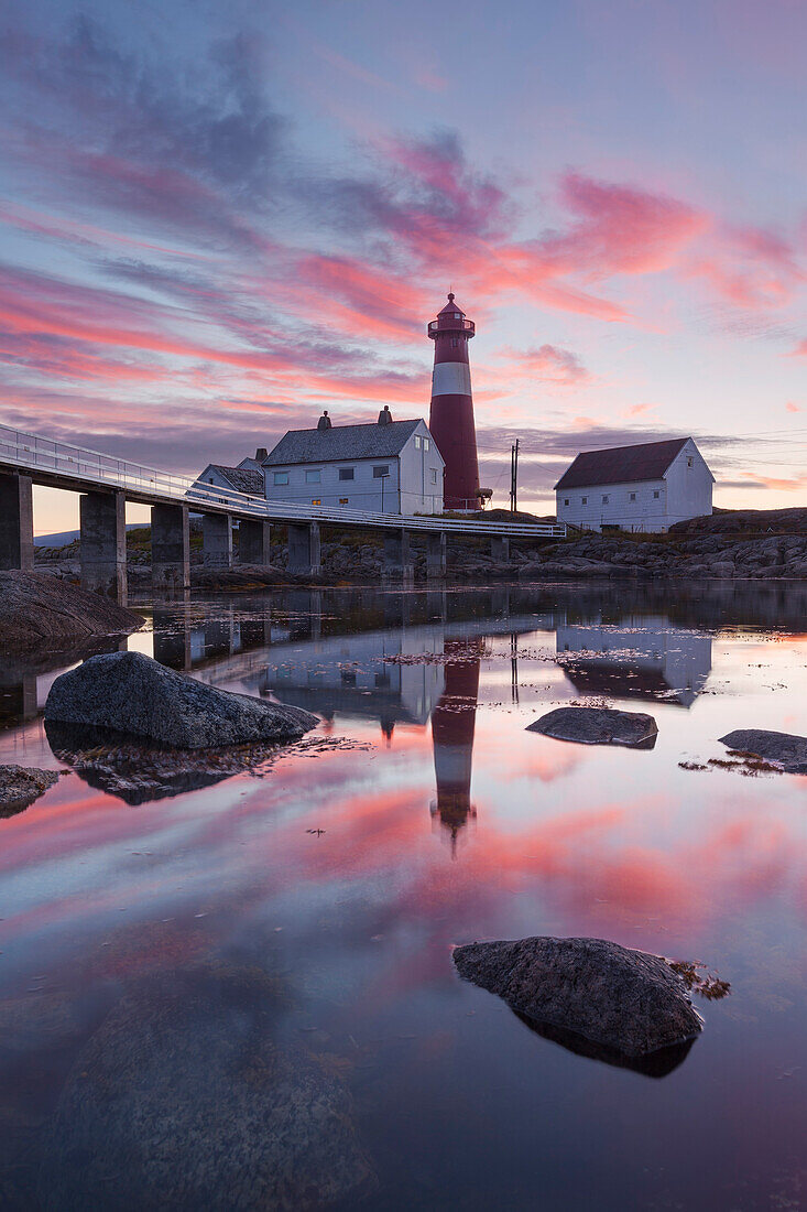 Malerischer Sonnenuntergang über dem Leuchtturm Tranøy Fyr im Sommer mit Spiegelung im Meer, Tranøya, Hamarøy, Nordland, Norwegen, Skandinavien