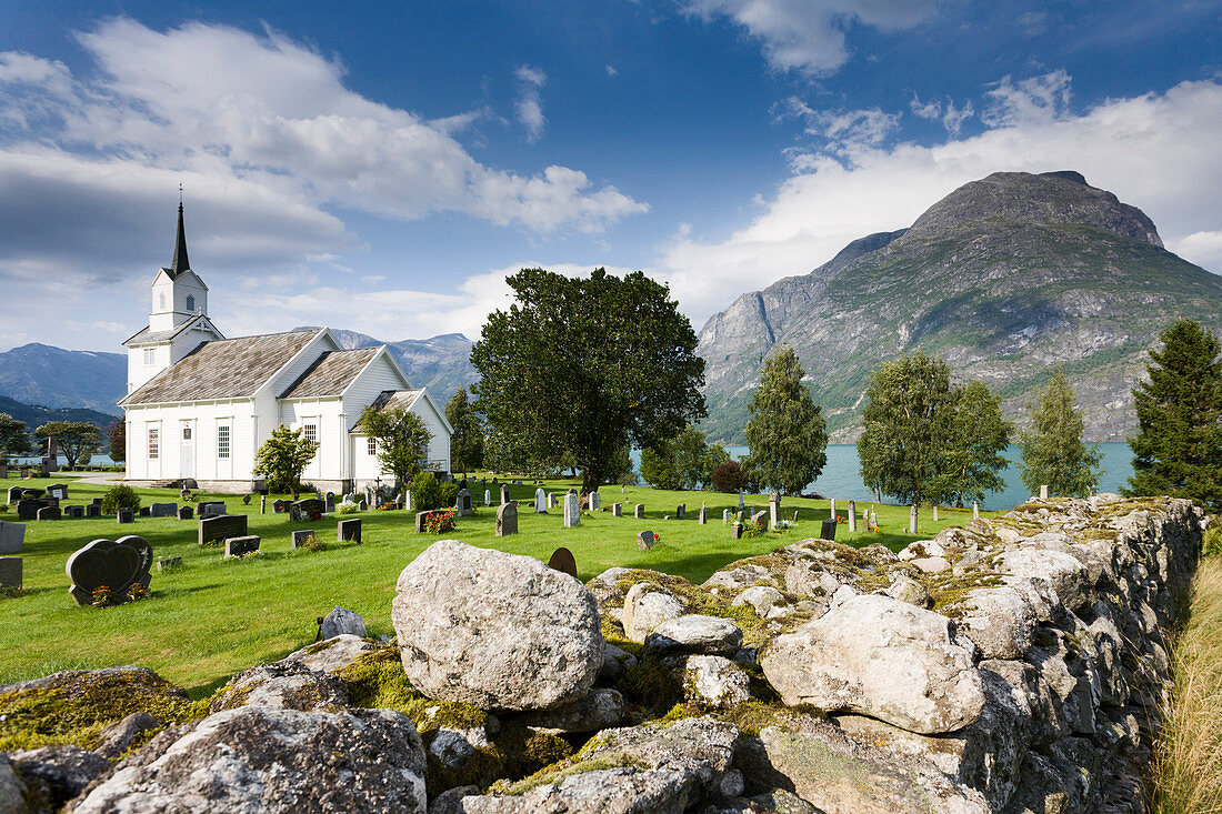 Stabkirche Fresvik mit Sonne und blauem Himmel, Sognefjord im Hintergrund, Sogn og Fjordane, Norwegen