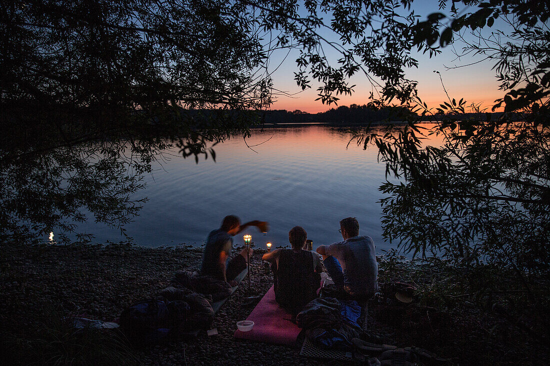 Three young men camping at a lake, Freilassing, Bavaria, Germany