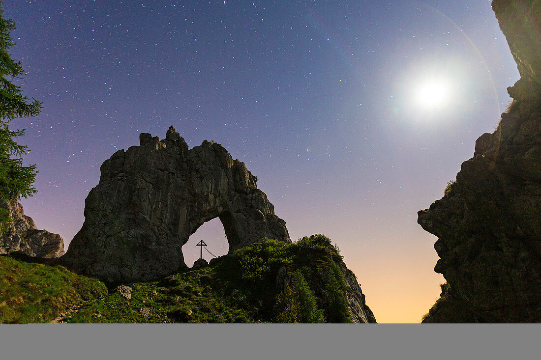 The natural Arch of Porta di Prada, on Grigna Settentrionale, in a full nigth moon, Province of Lecco, Lombardy, Italy