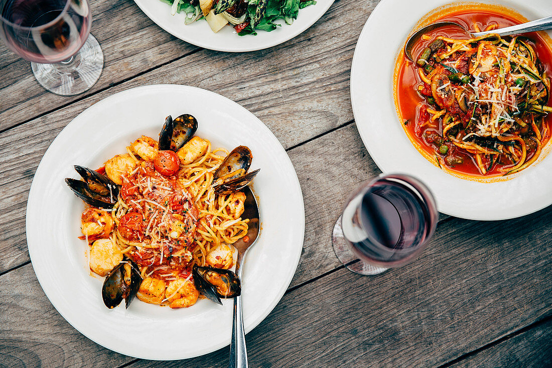 Plates of seafood and pasta with wine glasses