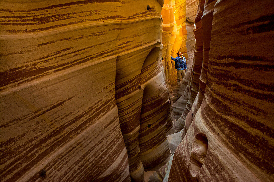 A woman hiking through Zebra Slot Canyon near the Hole in the Rock Road, Grand Staircase-Escalante National Monument, Escalante, Utah.