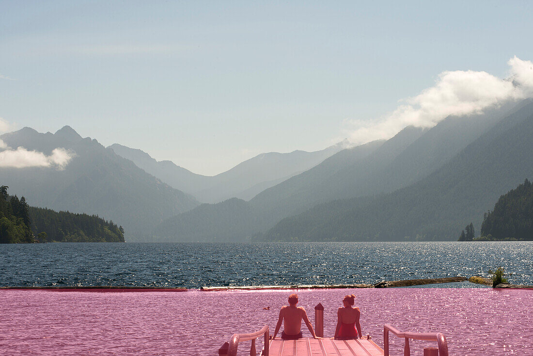 A couple sits on the end of a dock overlooking Lake Crescent in Olympic National Park, Washington on June 4, 2014.