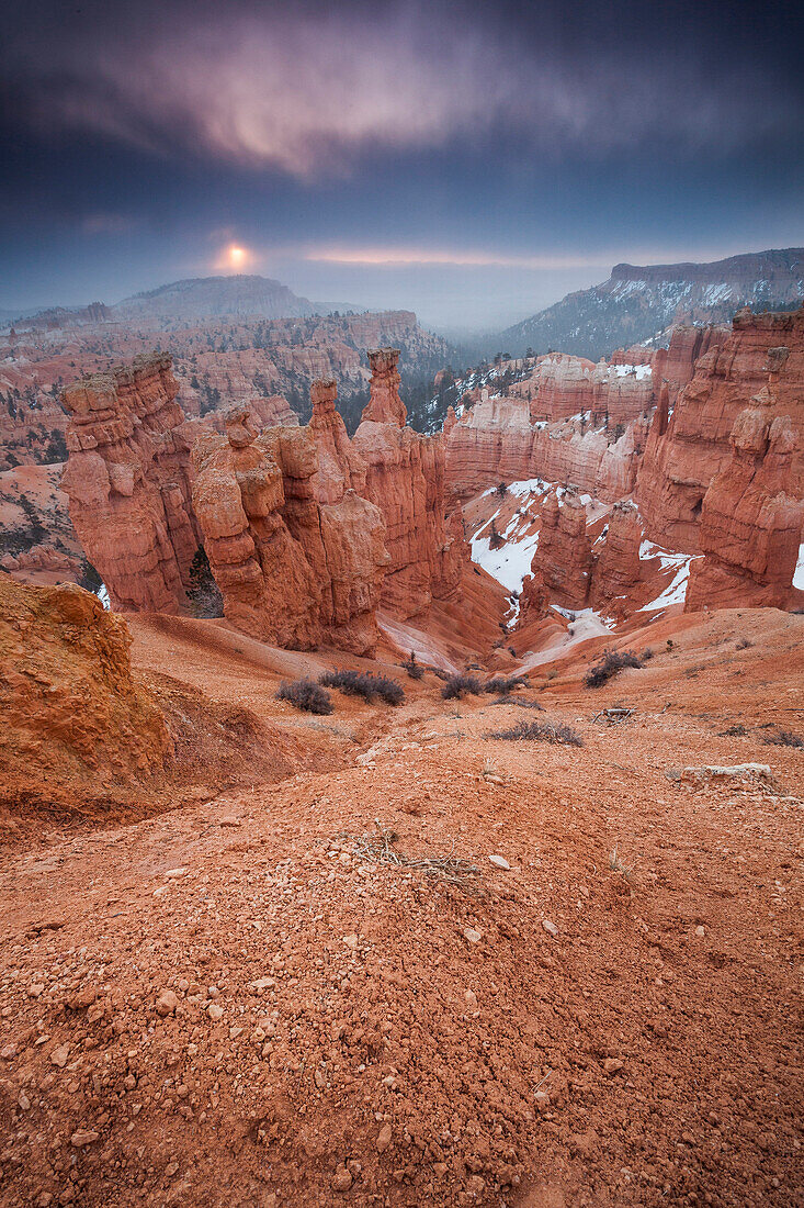 The sun rises through a cloudy sky over Thor's Hammer at Bryce Canyon National Park, UT.