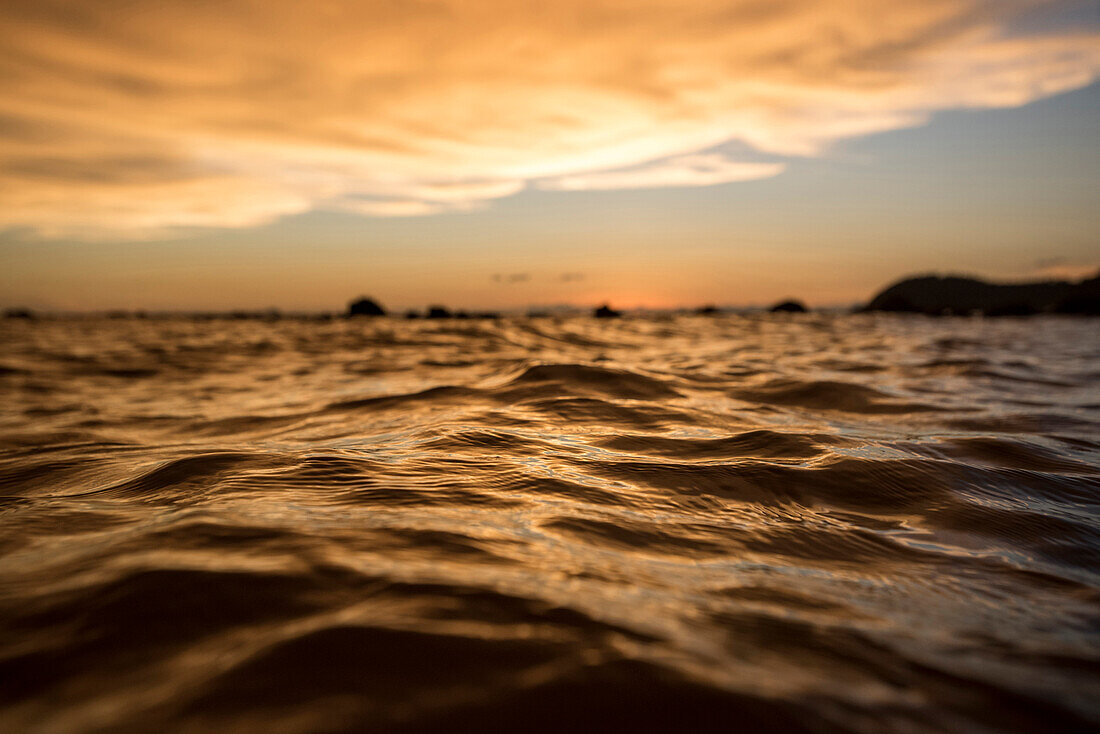 The color from clouds lit up from the setting sun reflected on the surface of the water on the island of Koh Jum, Thailand, on May 4, 2015.