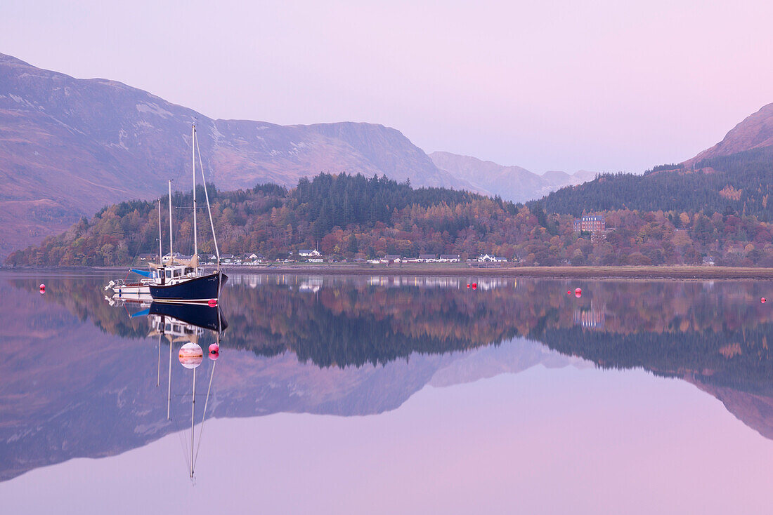 Yachts moored on a mirror still Loch Leven during twilight, Glencoe, Highland, Scotland, United Kingdom, Europe