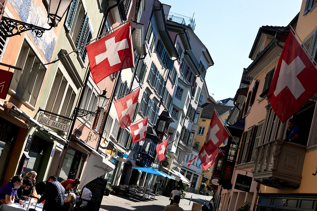 Swiss flags hang from shops on Augustinergasse, Zurich, Switzerland
