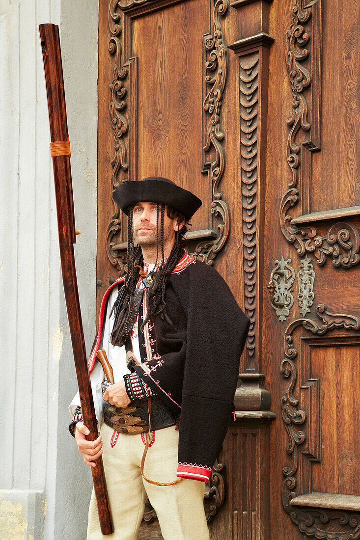 Musician Peter Tazky in front of the Jesuit Church at Bratislava (Pressburg) on the river Danube , Slovakia , Europe