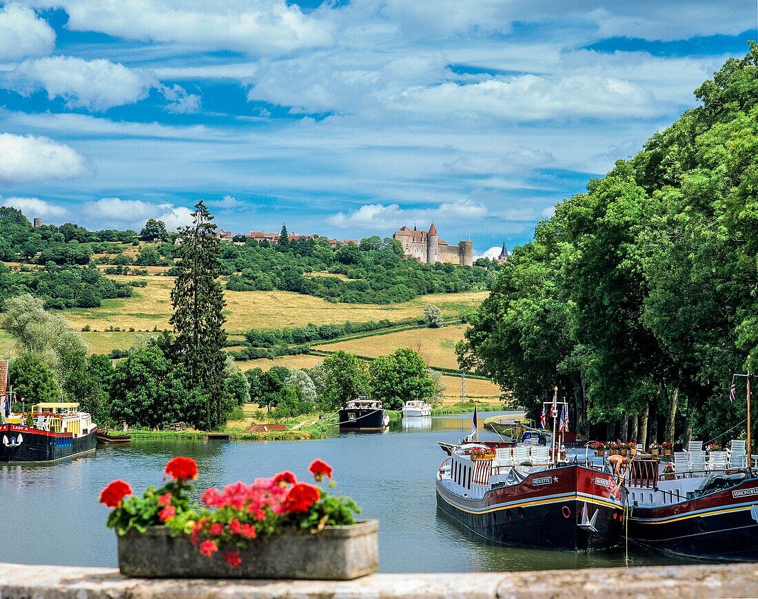 Moored cruise barges, Vandenesse-en-Auxois harbour, Burgundy canal, Châteauneuf-en-Auxois castle, Côte-d´Or, France.