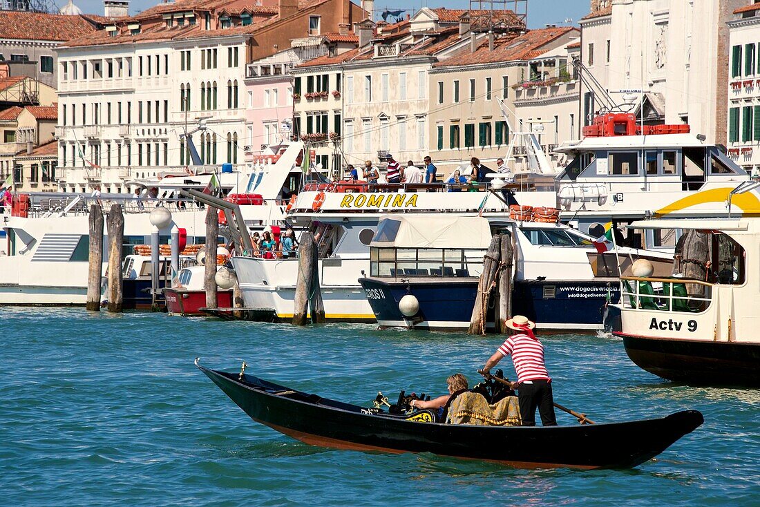 Gondola and gondolier, Palaces facades,boats and vaporetto, Canal Grande, Venice, Venetia, Italy.