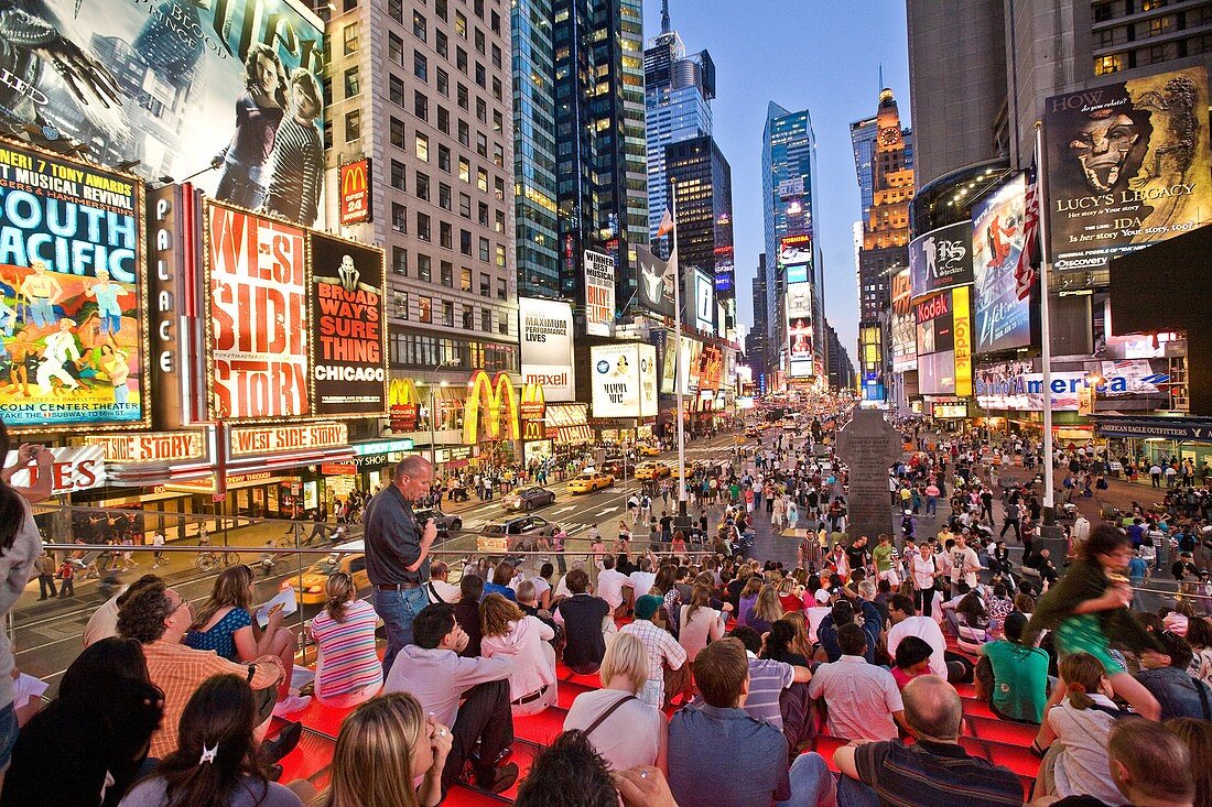 New York, city, people sitting on bleachers in the middle of Times Square in New York City.