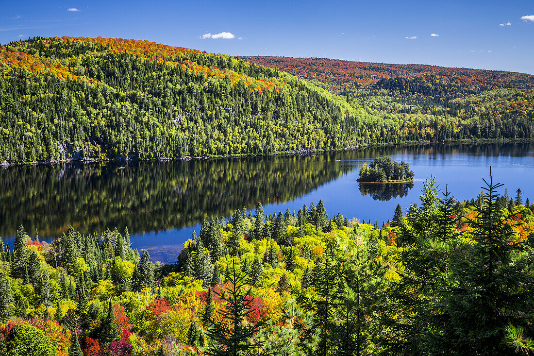 Brilliant fall foliage reflections in La Maurice National Park, Quebec, Canada.