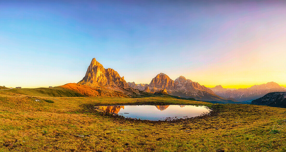 Gusela mountain at sunrise reflected in small lake, Giau Pass, Dolomites, Veneto, Italy.