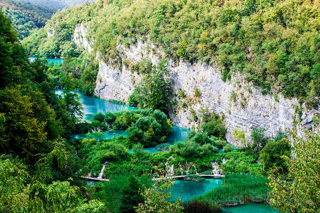 Plitvice Lakes, Croatia, Europe. tourists walking on the pier in the middle of the turquoise lakes