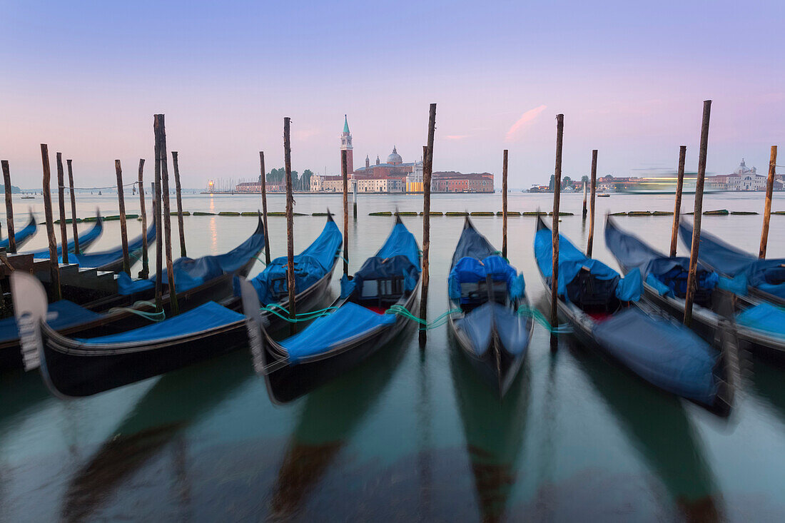 Venice, Italy. The gondolas swaying rocked by the sea in the Grand Canal, in front of St. Giorgio Maggiore.