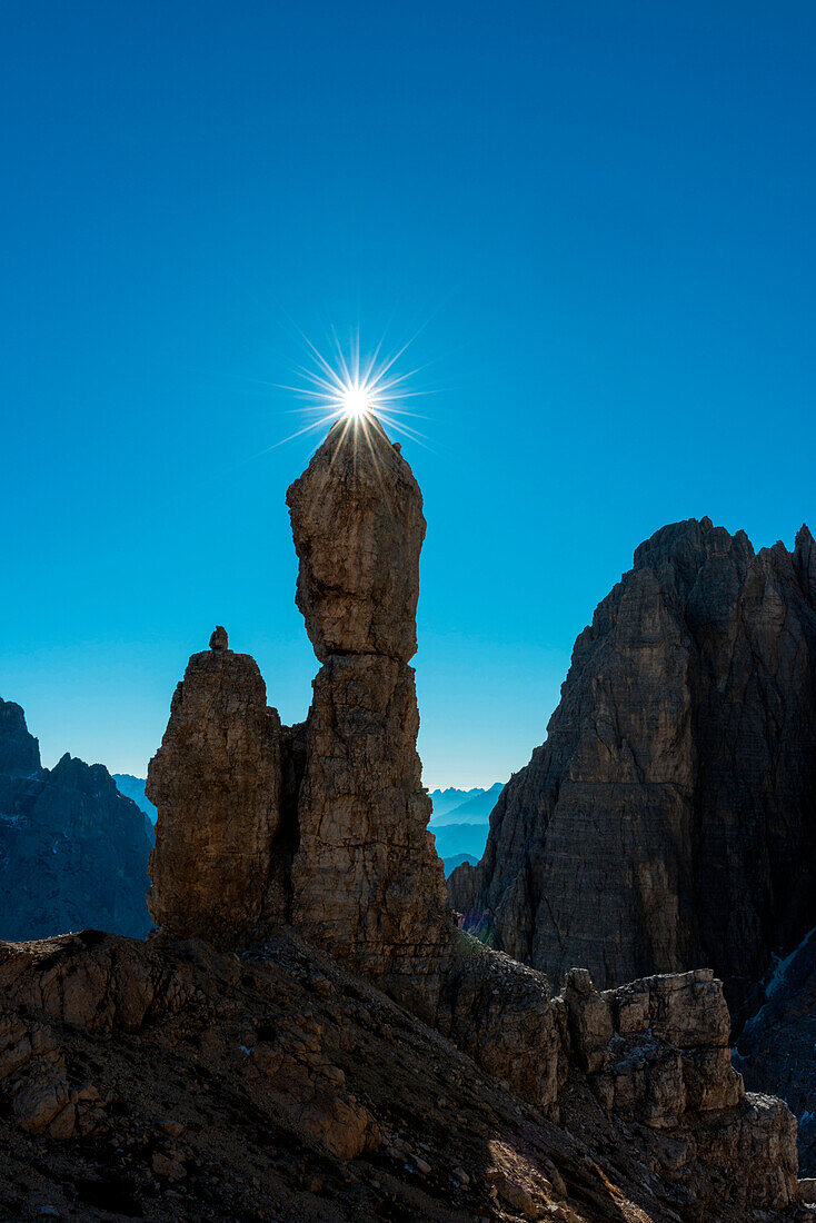 Auronzo, Dolomites, Veneto, Italy. Star sun exactly on the summit of Salsiccia near Refuge Carducci