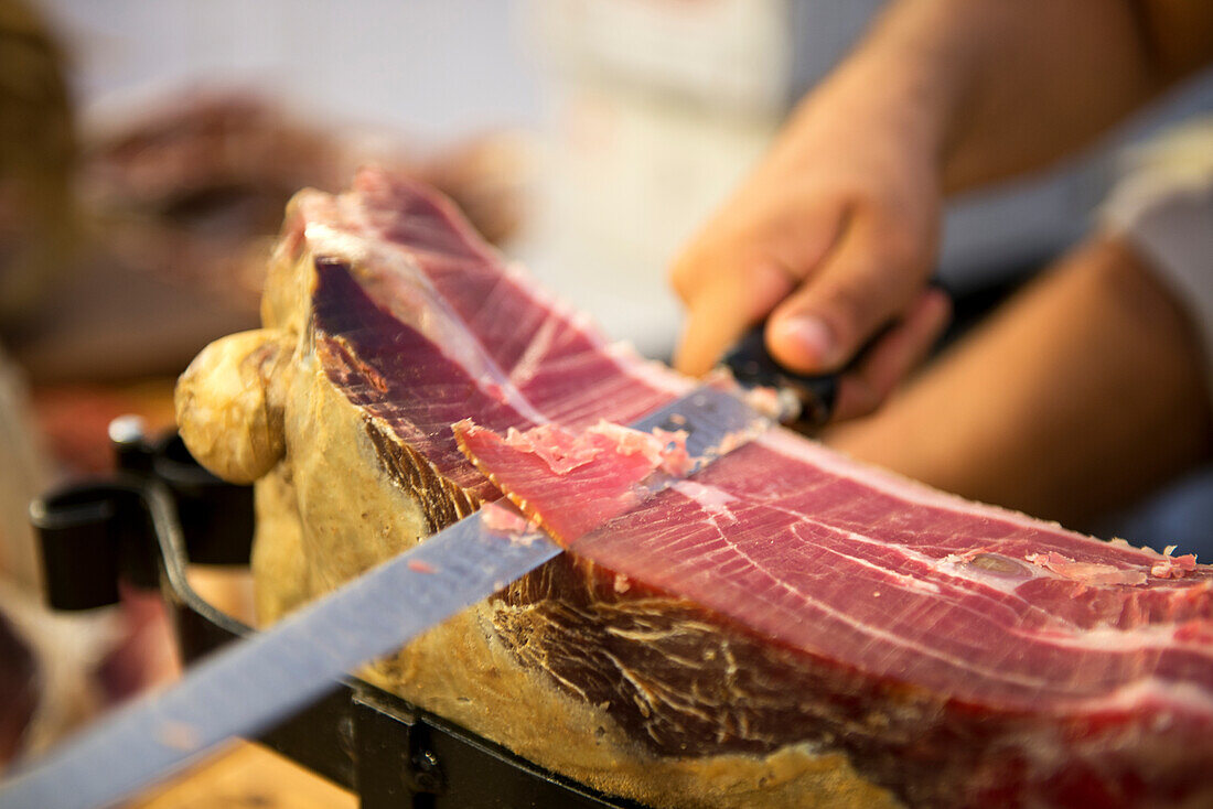 Ein Verkäufer schneide Prosciutto am Wochenmarkt in Sulmona