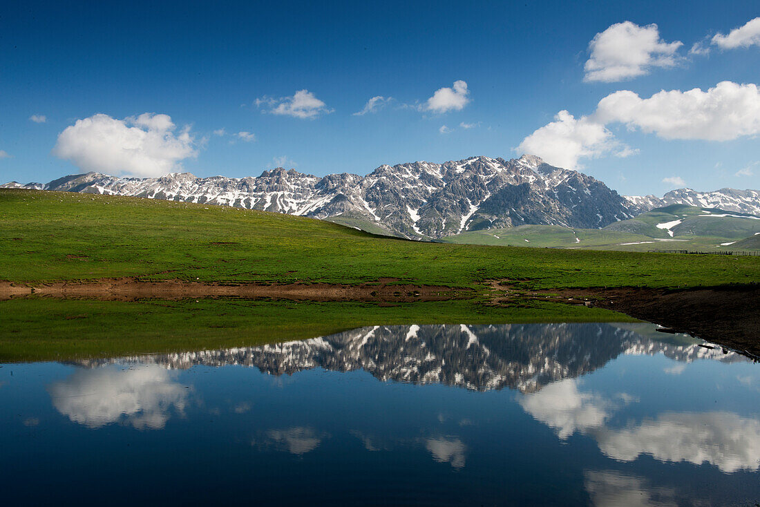 The mountains of the Gran Sasso range mirrow in a mountain tarn on the Campo Imperatore