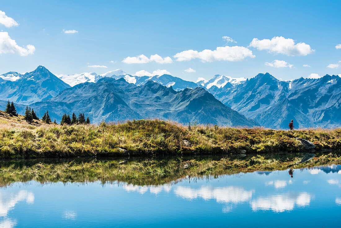 A mountain lake with mountain scenery, hiker and reflexion, Kitzbühel Alps, Kitzbühel, Tyrol, Austria