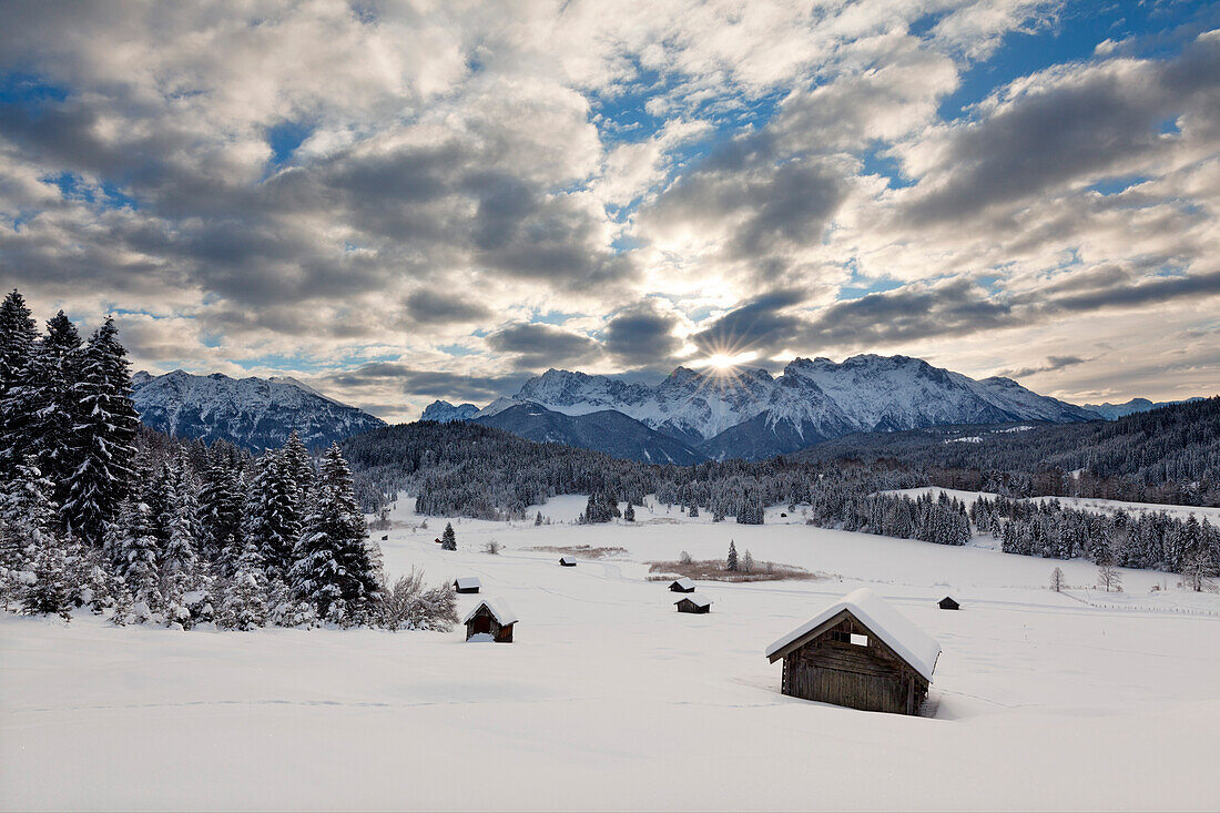 Winterlandschaft mit Heustadeln am Geroldsee, Blick auf Soierngruppe und zum Karwendel, Bayern, Deutschland