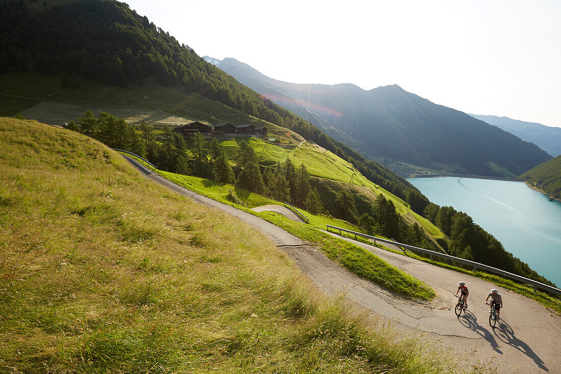 Couple with mountainbike riding up a road