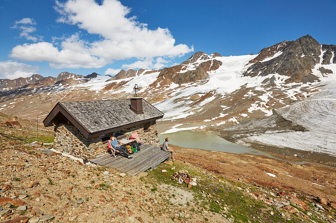 Couple sitting in front a mountain hut