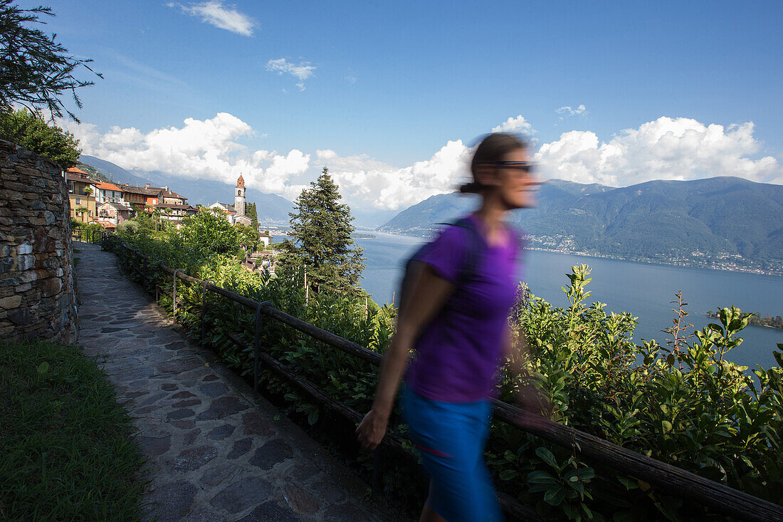 Junge Wanderin geht durch eine alte Stadt, Ronco, Tessin, Schweiz