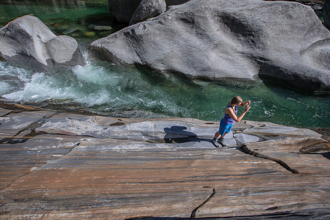 Wanderin steht auf einem Felsen an einem Fluss, Val Verzasca, Tessin, Schweiz