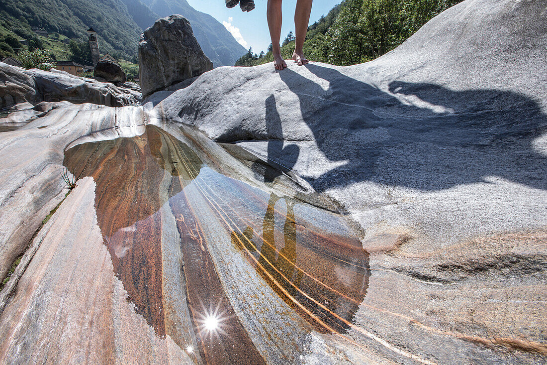 Junge Wanderin geht auf Felsen ziwschen einem Fluss, Val Verzasca, Tessin, Schweiz