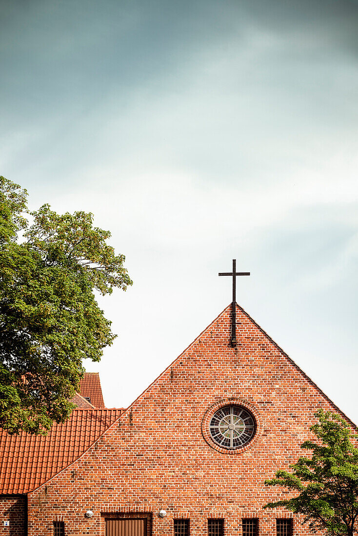 christliches Kreuz an roter Backstein Fassade einer Kirche, UNESCO Hansestadt Wismar, Mecklenburg-Vorpommern, Deutschland