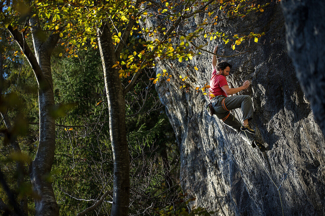 Junger Mann klettert an einer Felswand, Schwaerzer Wand, Bayern, Deutschland