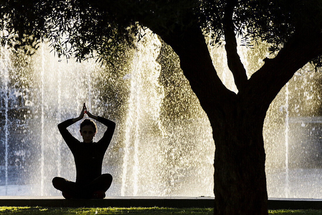 Woman practicing Yoga, Riera Park, Palma, Mallorca, Balearic Islands, Spain.