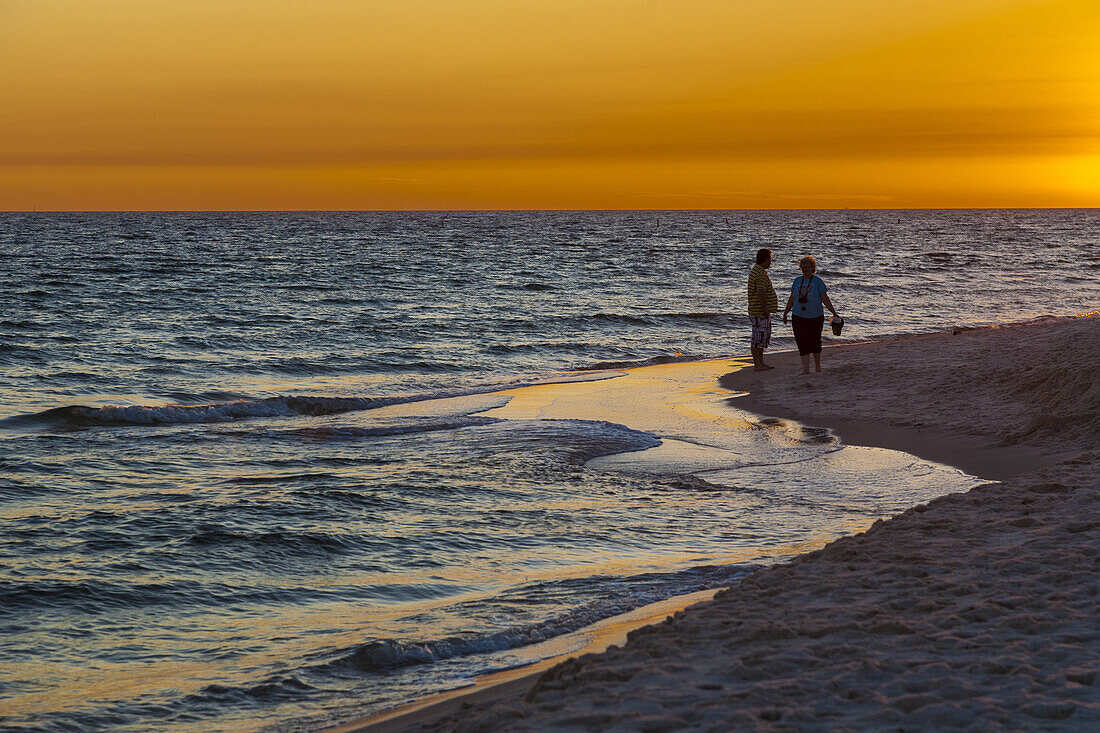 Couple on the beach during sunset at Gulf Shores, Alabama.