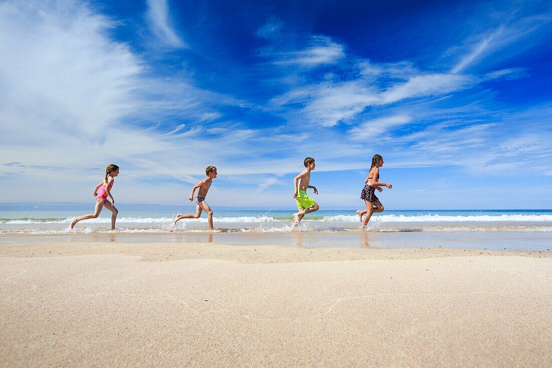 children running along sandy beach, Scotland.