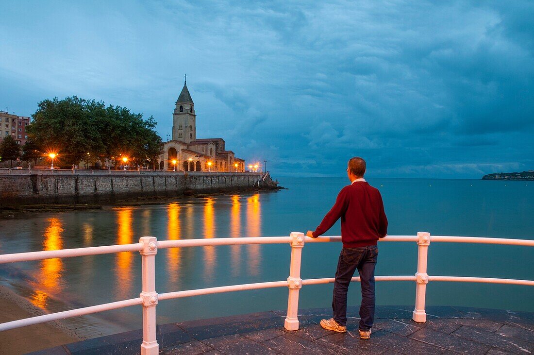 Mann auf der Promenade, Nachtansicht. Gijon, Asturien, Spanien.