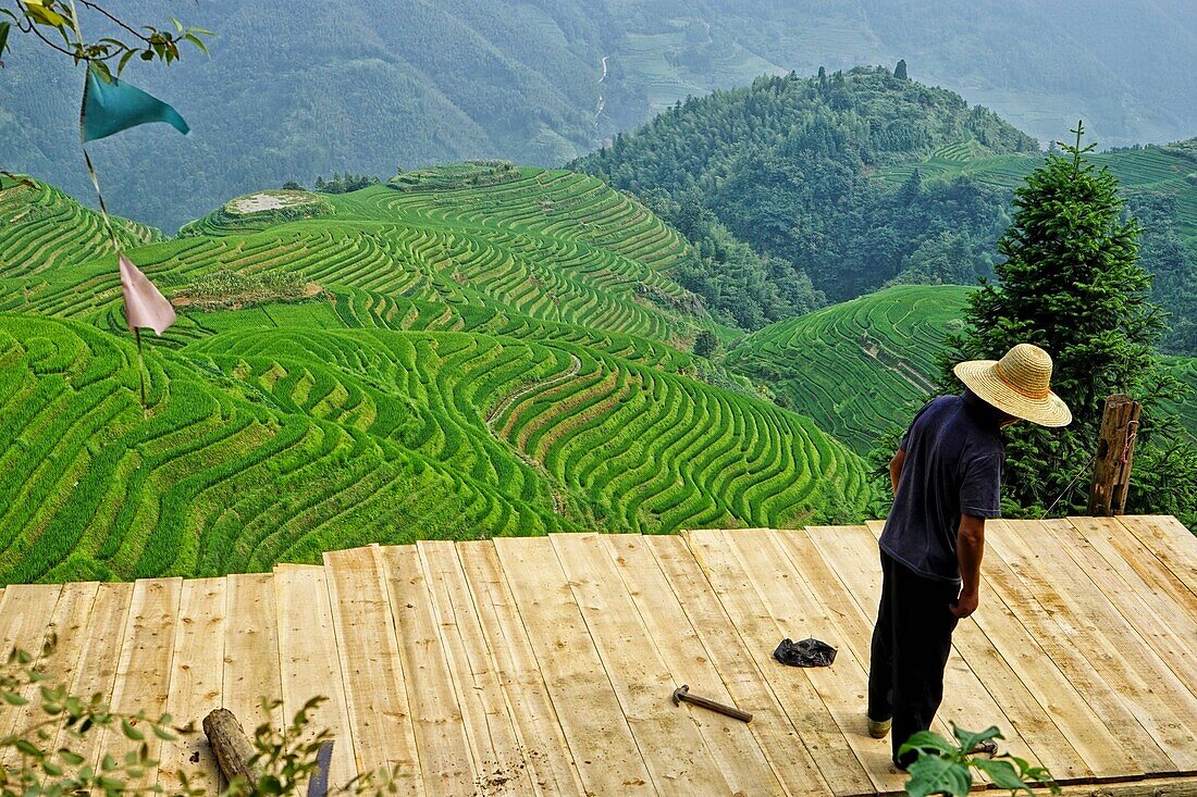 Man works in the amazing rice terraces of LongJi in Guangxi, China.