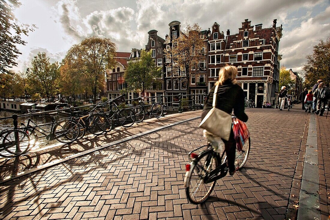 Bicyclist crossing the the Hemonybrug bridge at Keizersgracht and Leidsegracht in Amsterdam.