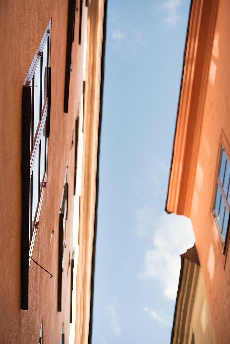 Low angle view of old buildings in Gamla Stan (Old Town) Stockholm, Sweden. The houses are close to each other with a narrow alley between.
