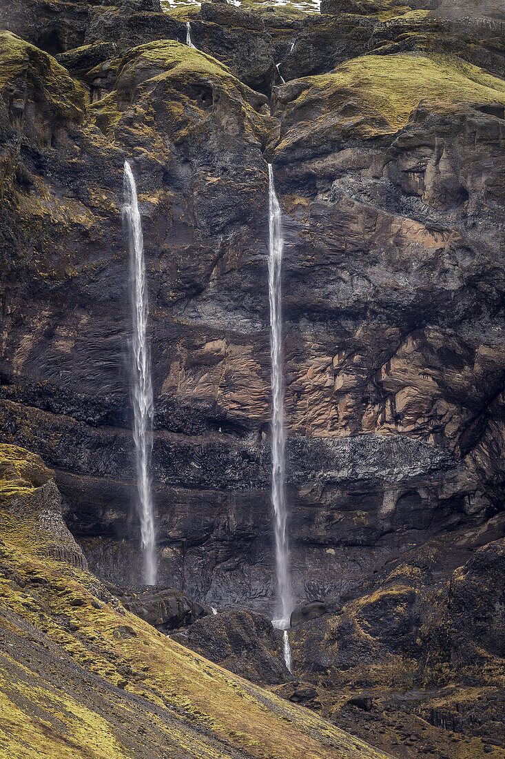 Waterfalls streaming out of the rocks, Mt. Lomagnupur, Eastern, Iceland.