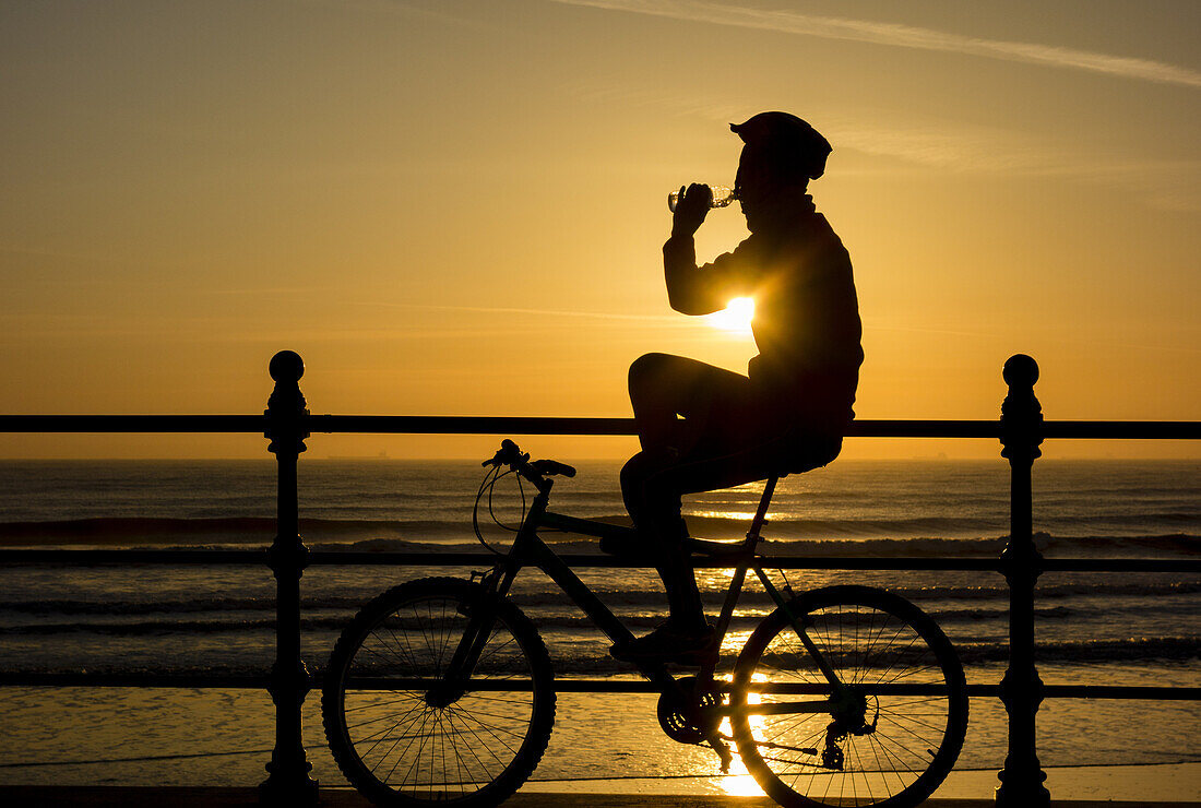 Mountain biker at sunrise at Seaton Carew on the north east coast of England, United Kingdom.