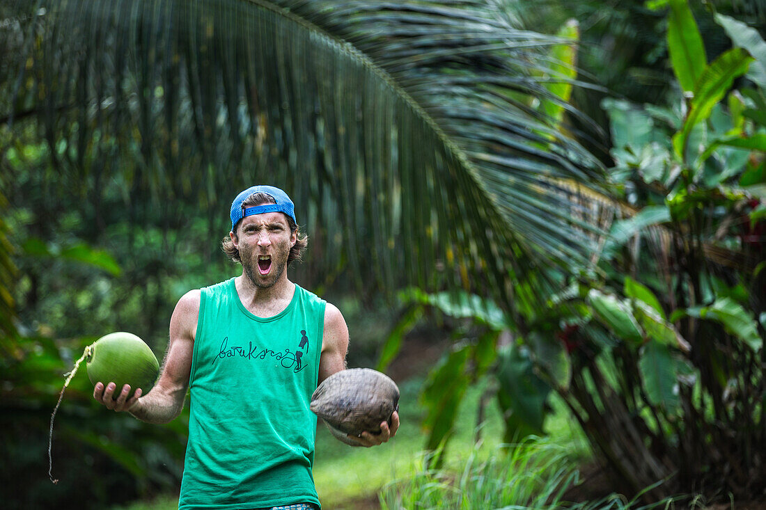 Junger Mann freut sich über seine Kokosnüsse, Sao Tome, Sao Tome und Príncipe, Afrika