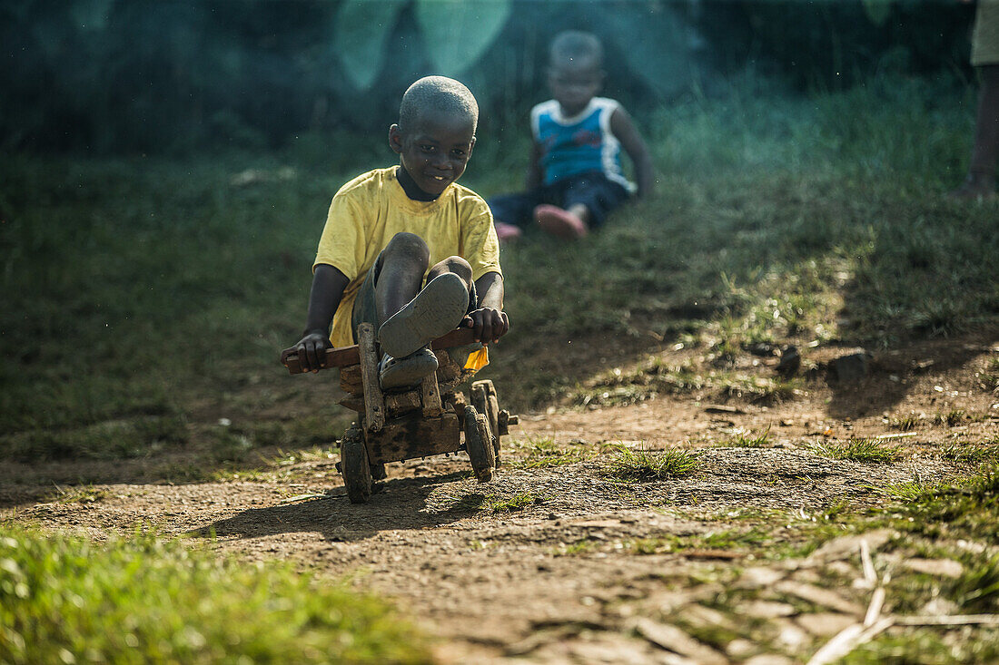 Little local boy riding on a simple wooden toy vehicle, Sao Tome, Sao Tome and Principe, Africa