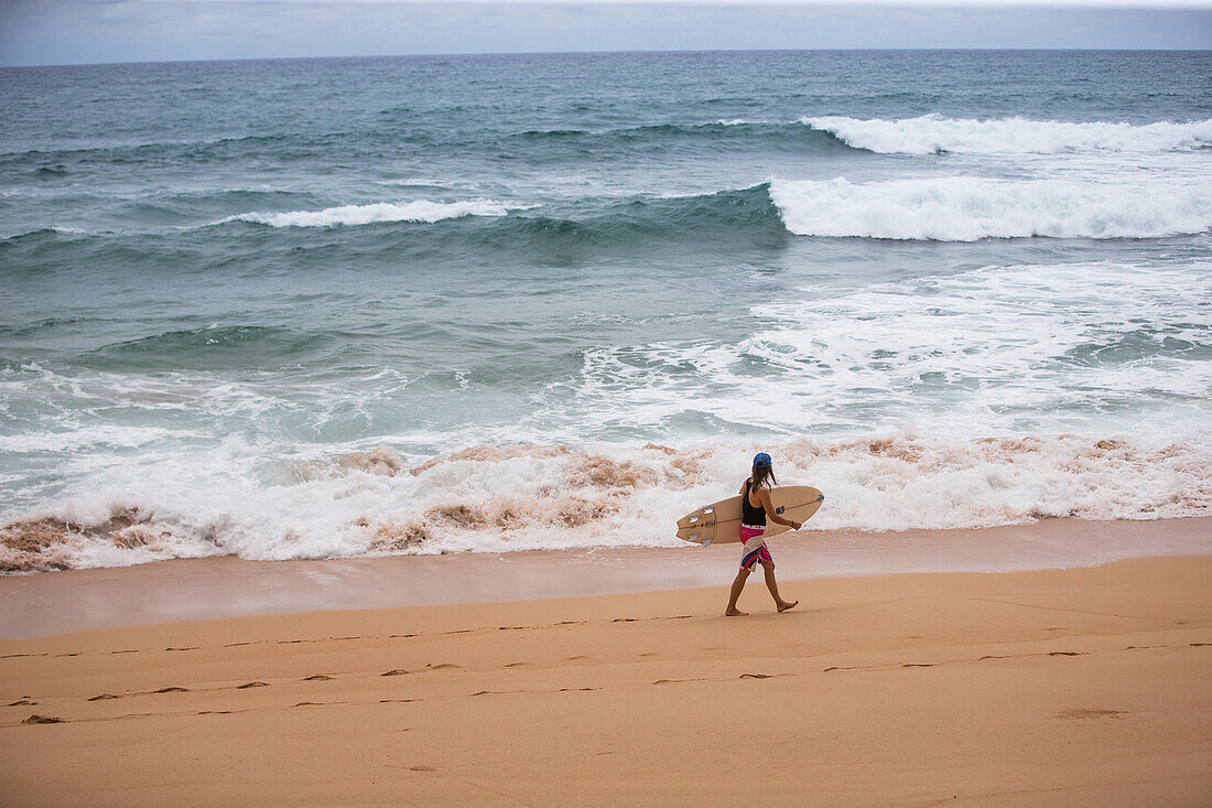 Young female surfer walking at the beach, Sao Tome, Sao Tome and Principe, Africa